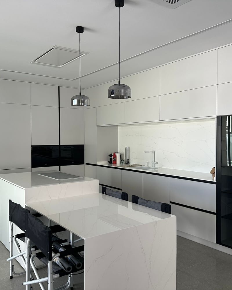 Cocina moderna blanca con isla y sillas altas